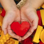 Lego red heart in child hands